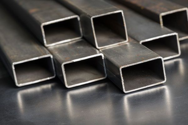 A Bunch Of Square Metal Pipes Are Stacked On Top Of Each Other On A Table — ADR Engineering in Collinsville, QLD