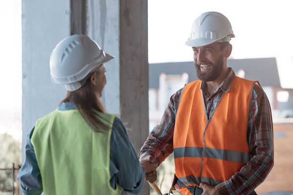 A Man and a Woman Are Shaking Hands on a Construction Site — ADR Engineering in Collinsville, QLD