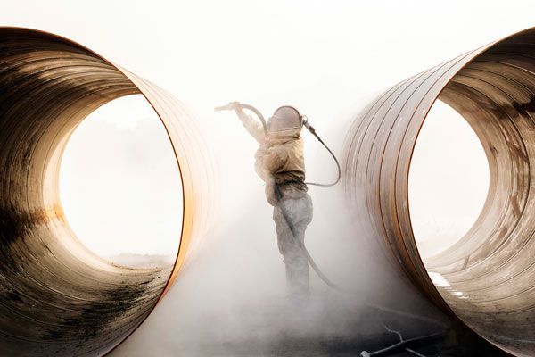 A Man Sandblasting a Huge Pipe — ADR Engineering in Collinsville, QLD