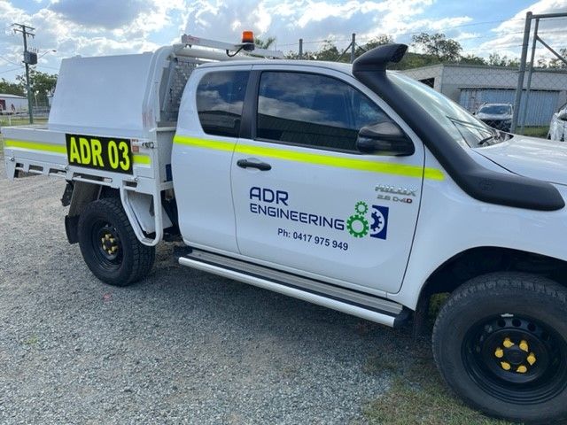 A White Truck With ADR Engineering Written On The Side Is Parked In A Gravel Lot — ADR Engineering in Collinsville, QLD