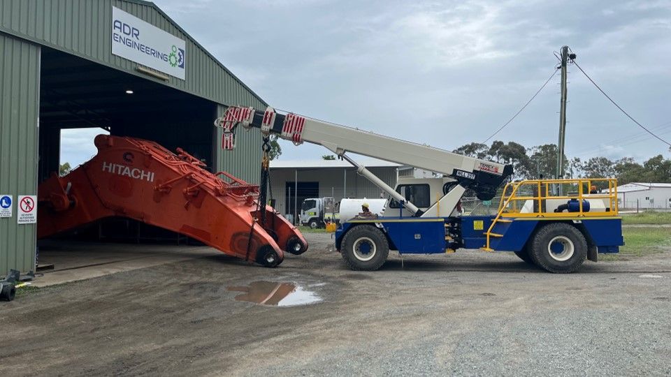 A Large Crane Is Parked In Front Of A Building — ADR Engineering in Collinsville, QLD