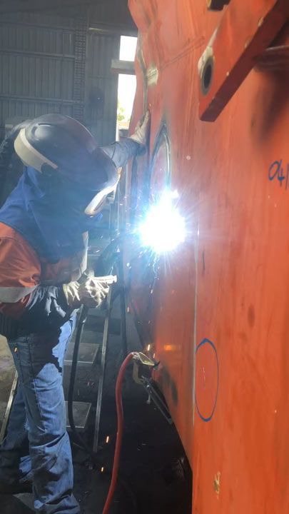 A Man Is Welding A Piece Of Metal In A Factory — ADR Engineering in Collinsville, QLD