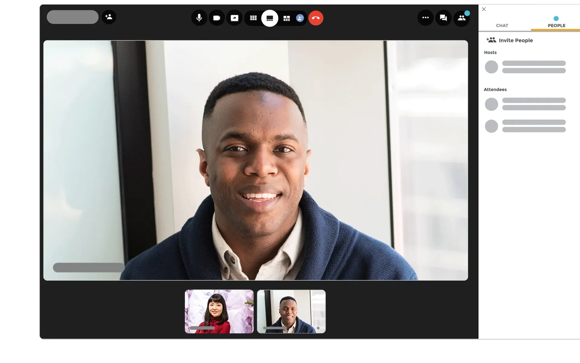 A man is smiling while having a video call with two other people.