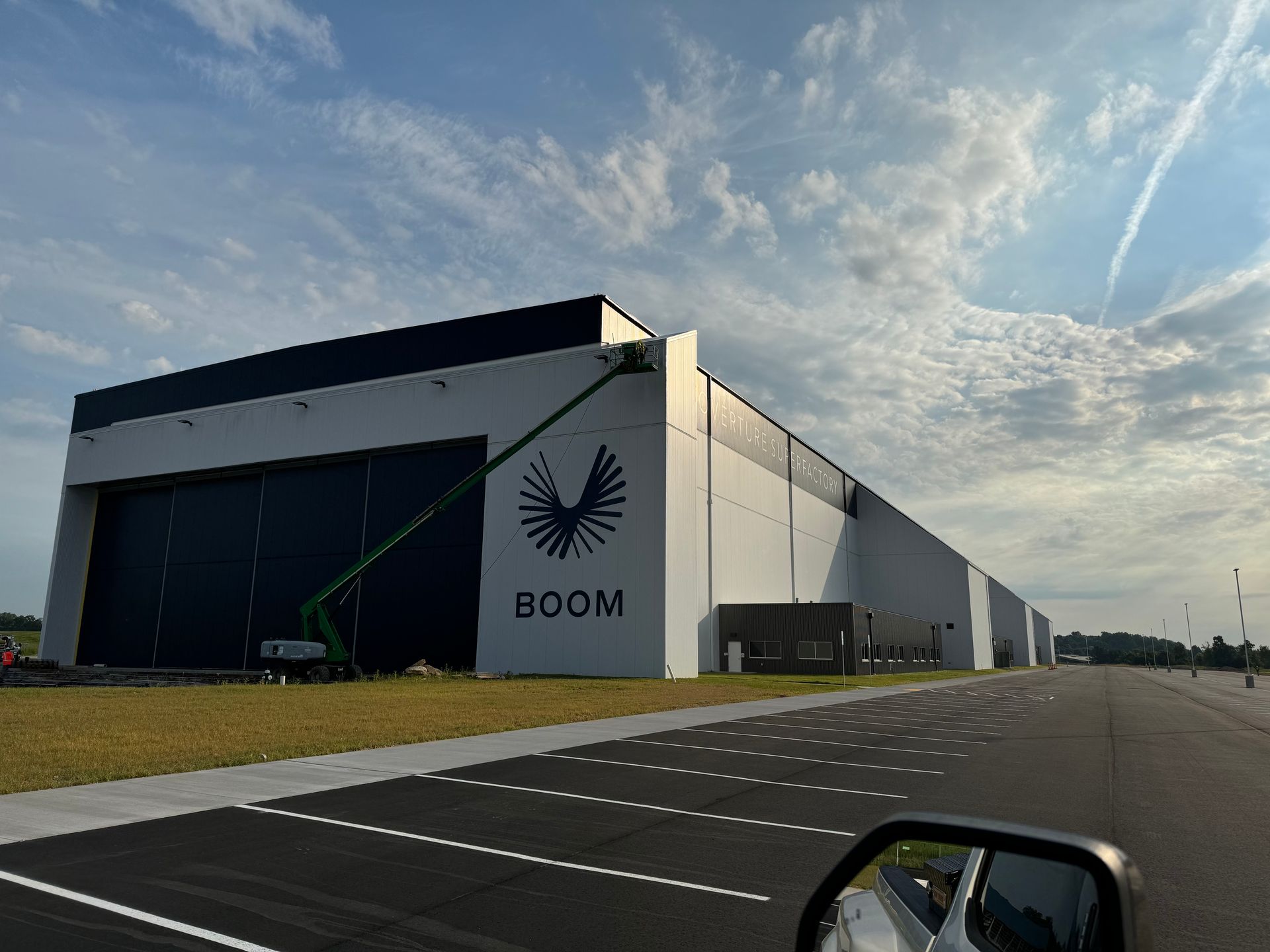 A person power washing a concrete wall, removing mold and grime.