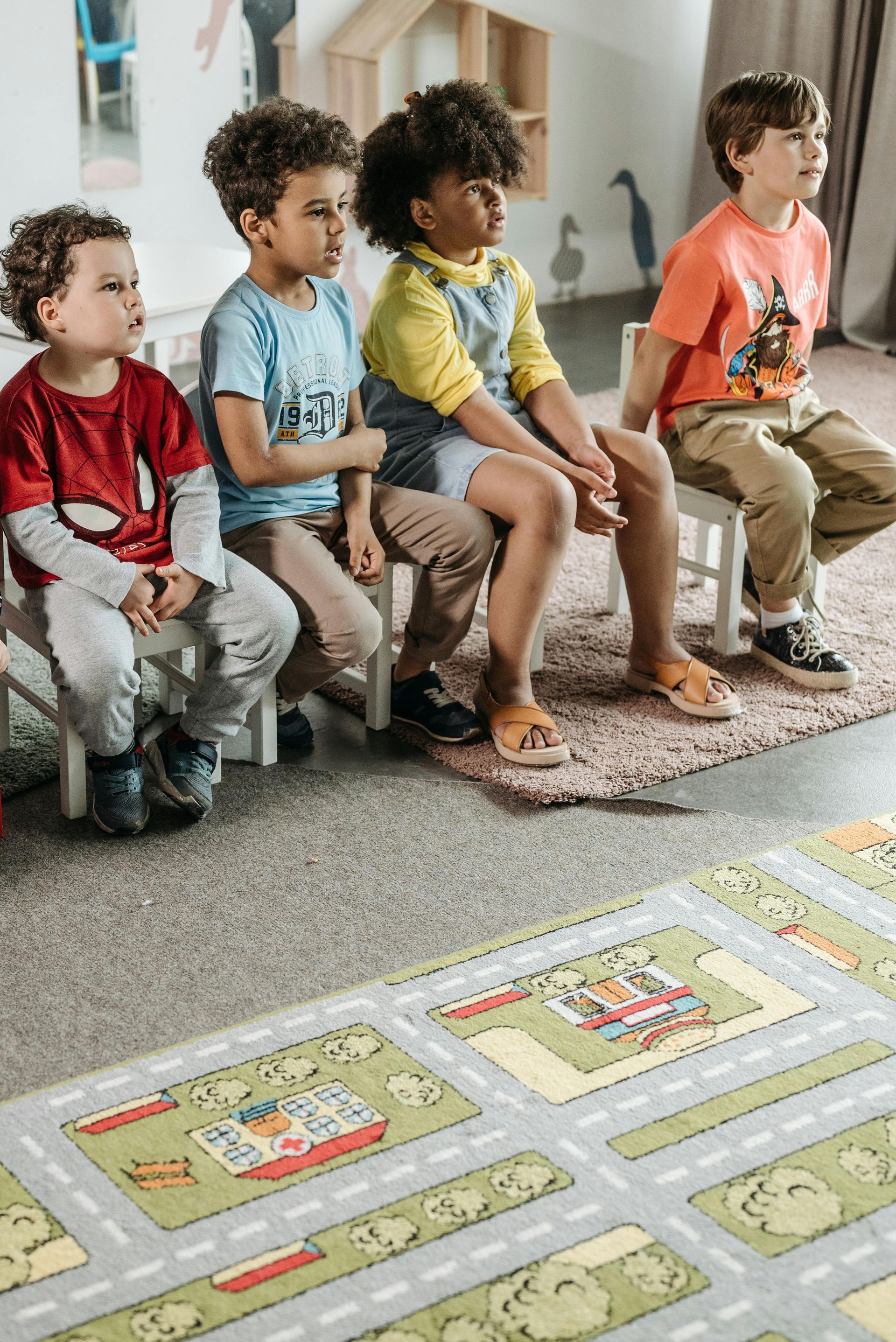 A group of children are sitting on the floor in a classroom.