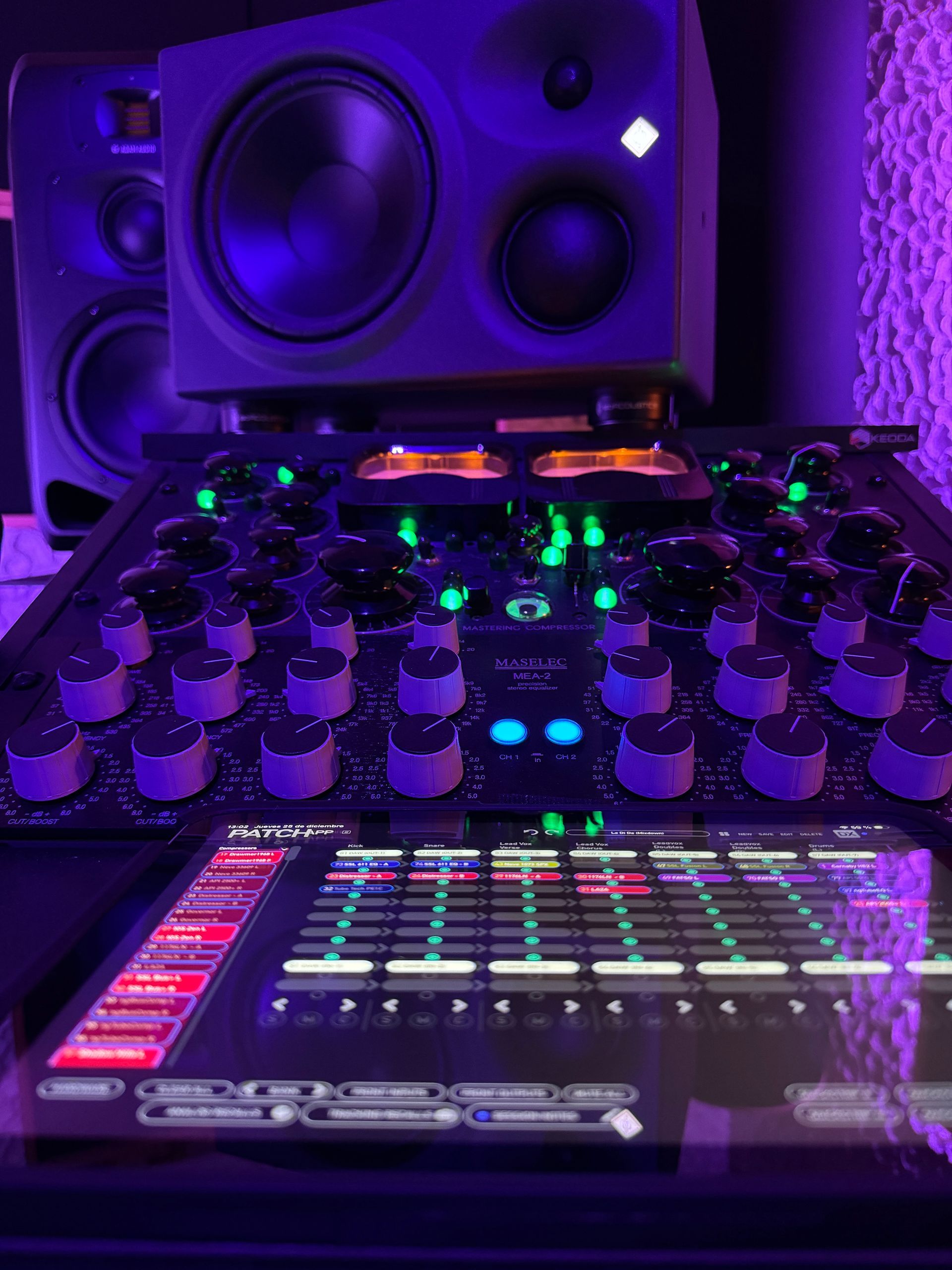 Mixing console with speakers lit by purple light.