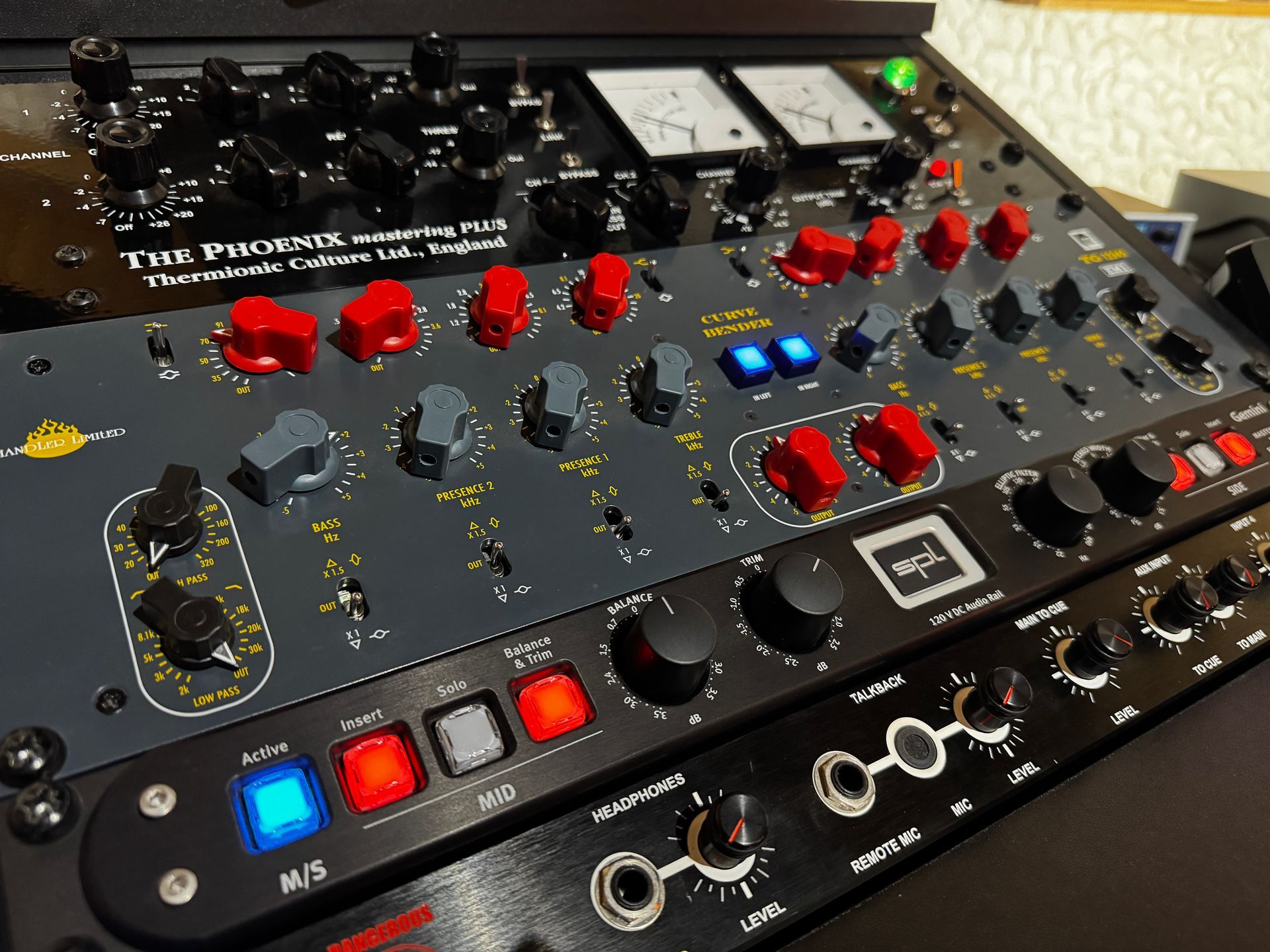 Audio equipment: a rack-mounted hardware unit with knobs, buttons, and meters in gray, red, and black.
