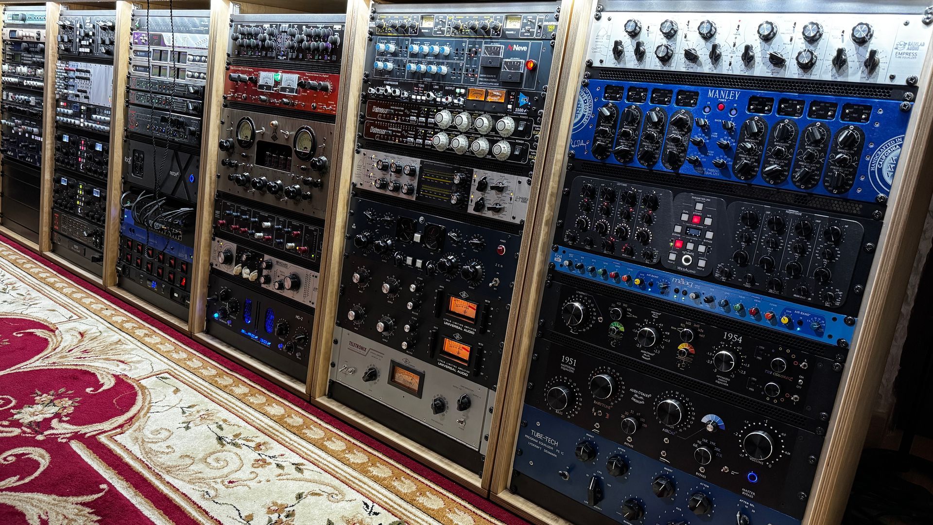 A collection of audio equipment racks in a recording studio setting.