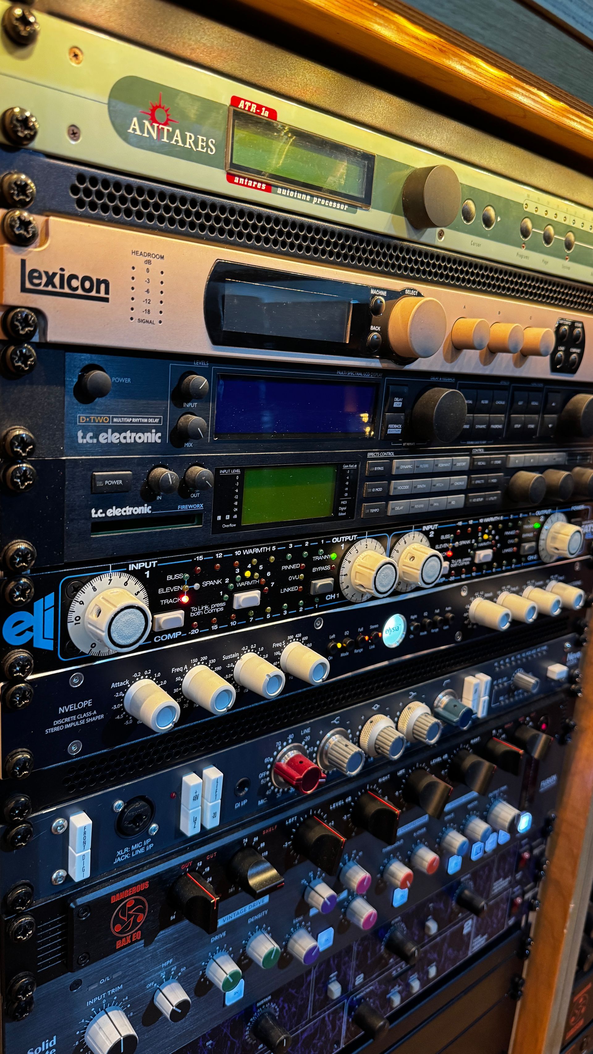 Rack of audio equipment with multiple devices and controls.