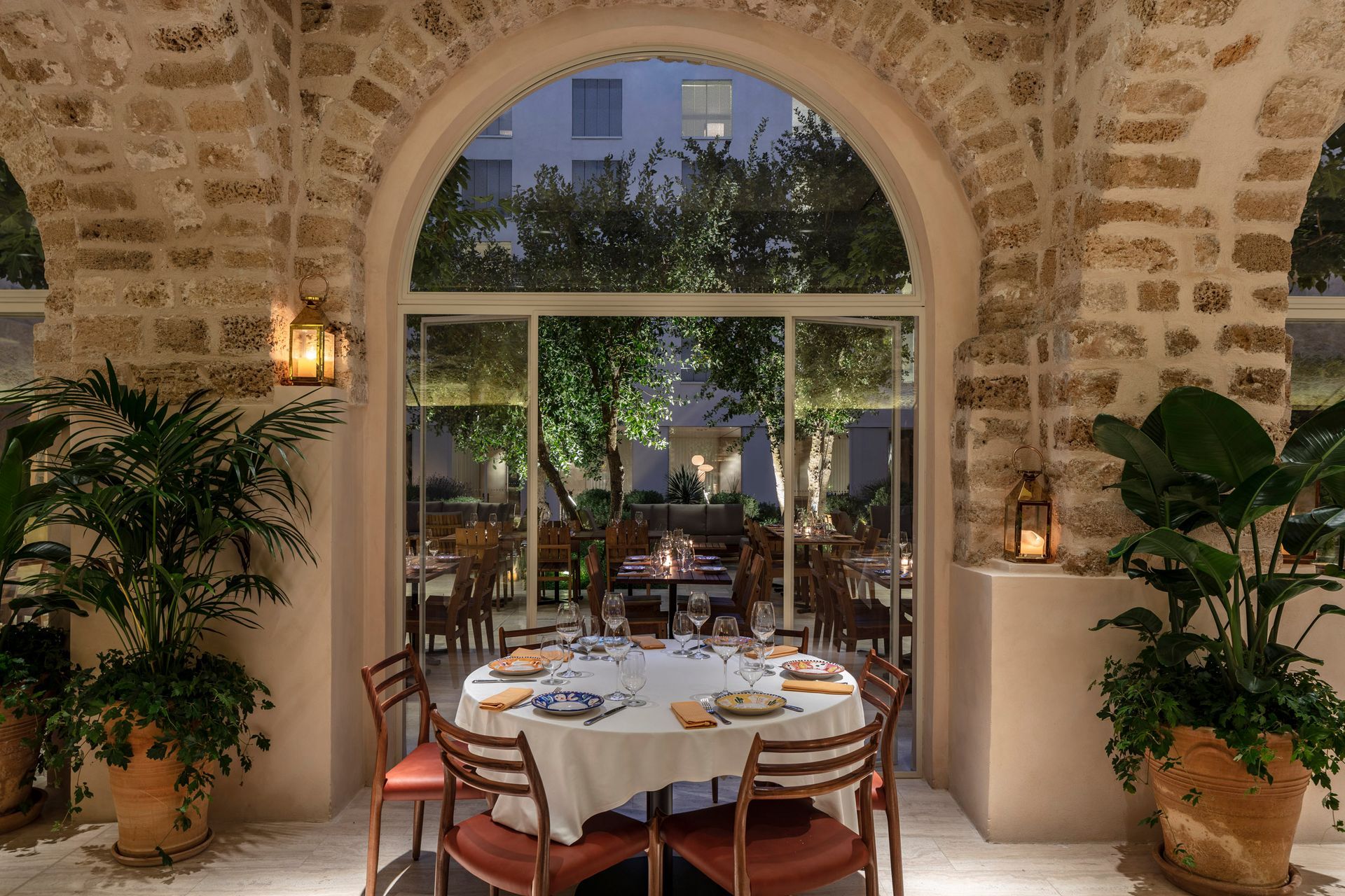 A dining room with a table and chairs in front of a large window.