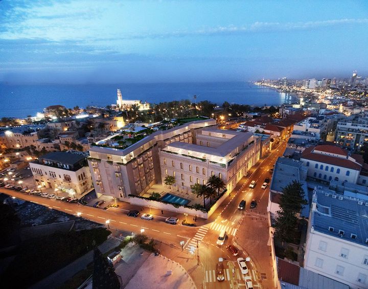 An aerial view of a city at night with the ocean in the background