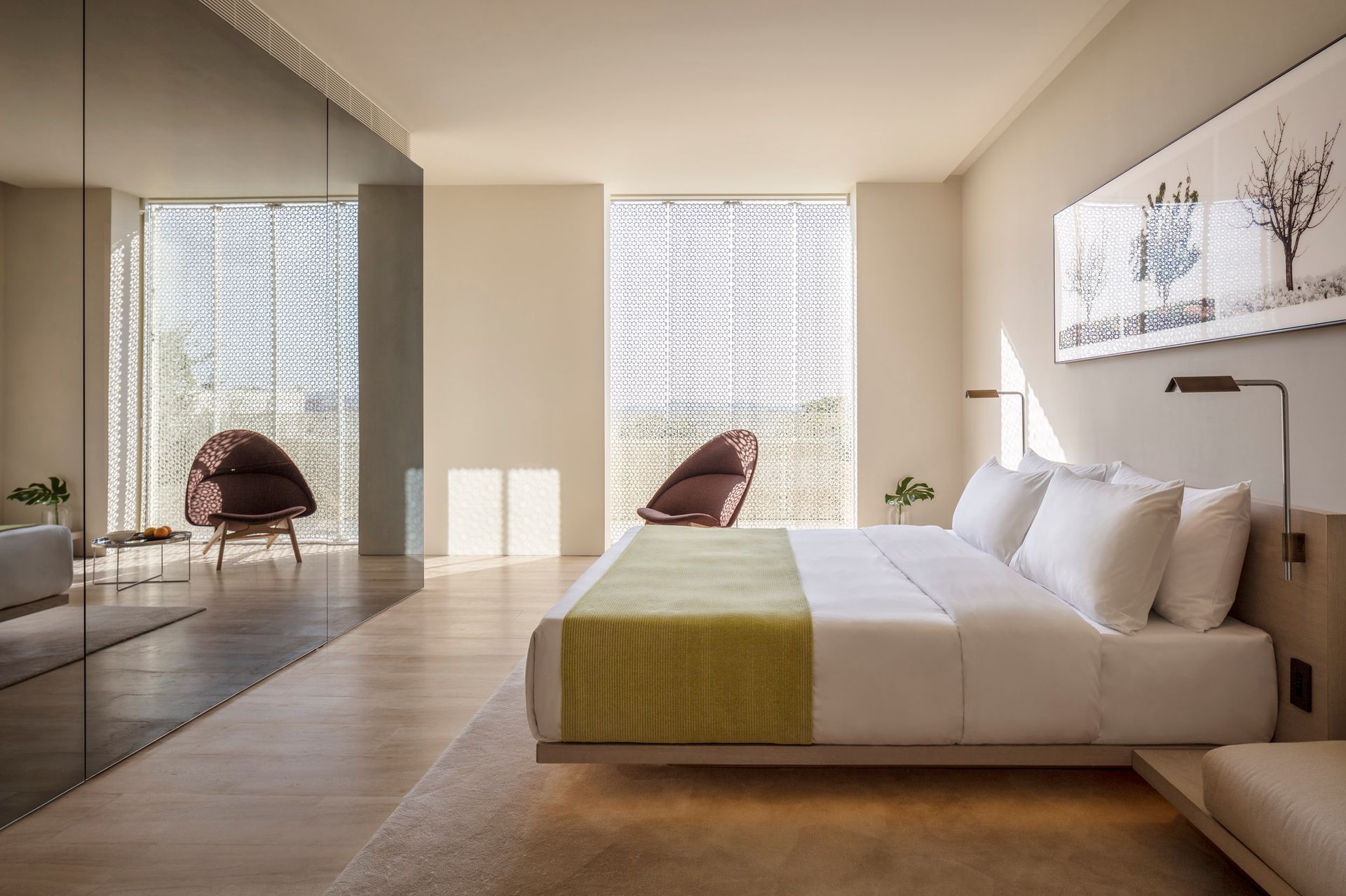 An artist 's impression of a hotel room with a large bed and chairs.