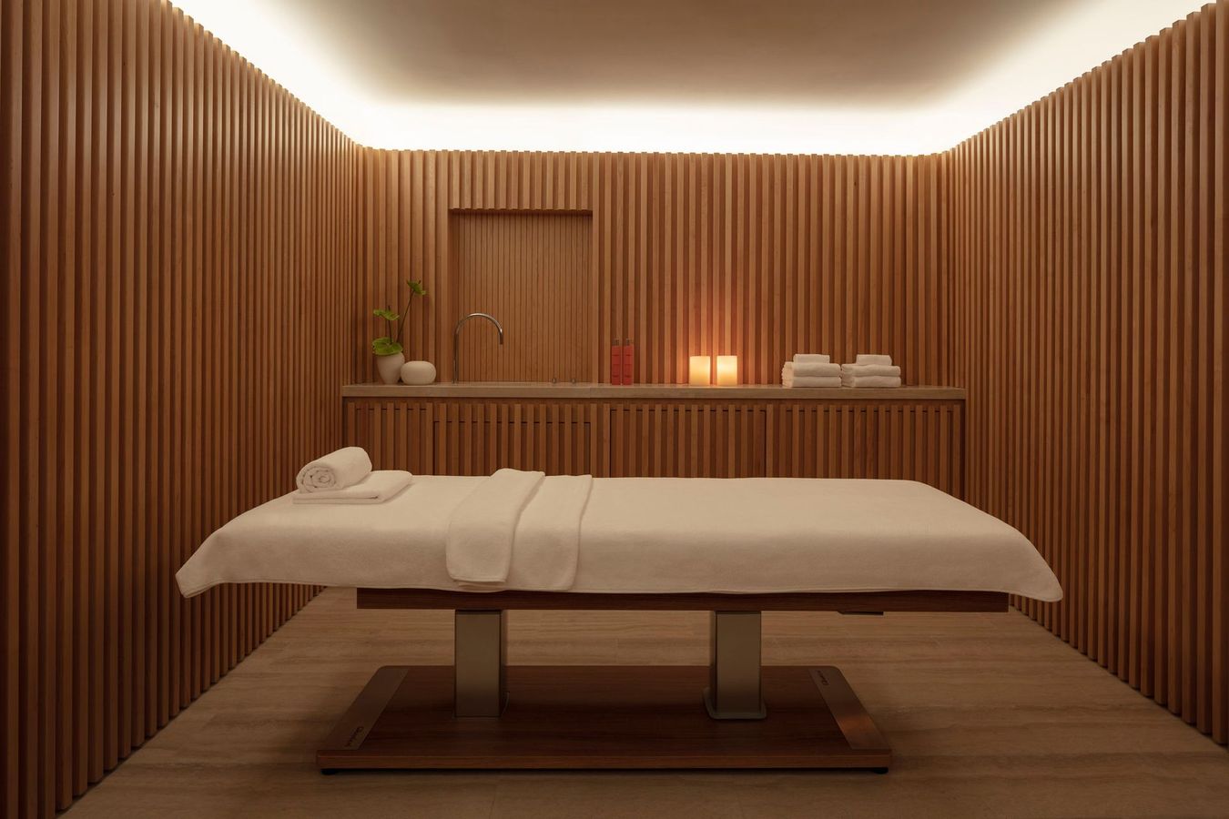 There is a massage table in the middle of the room.