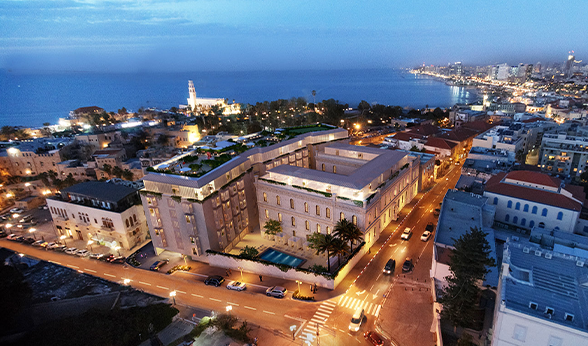 An aerial view of a city at night with a large building in the middle
