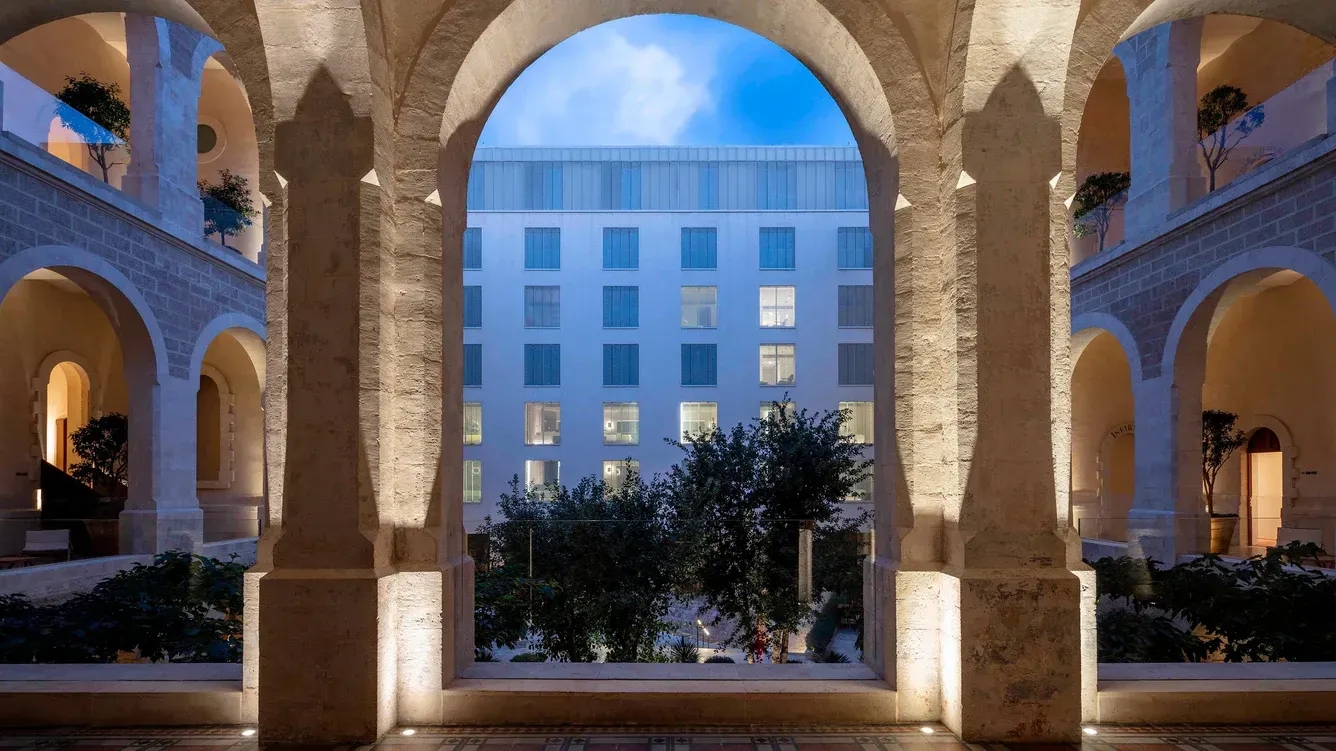 A view of a building through an archway at night.