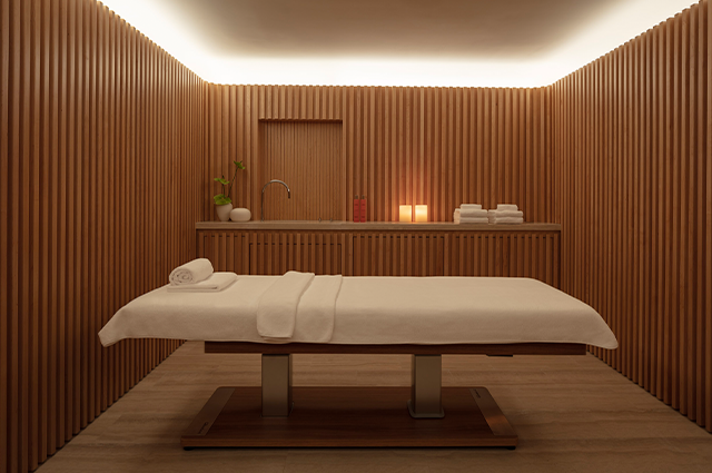 There is a massage table in the middle of the room.