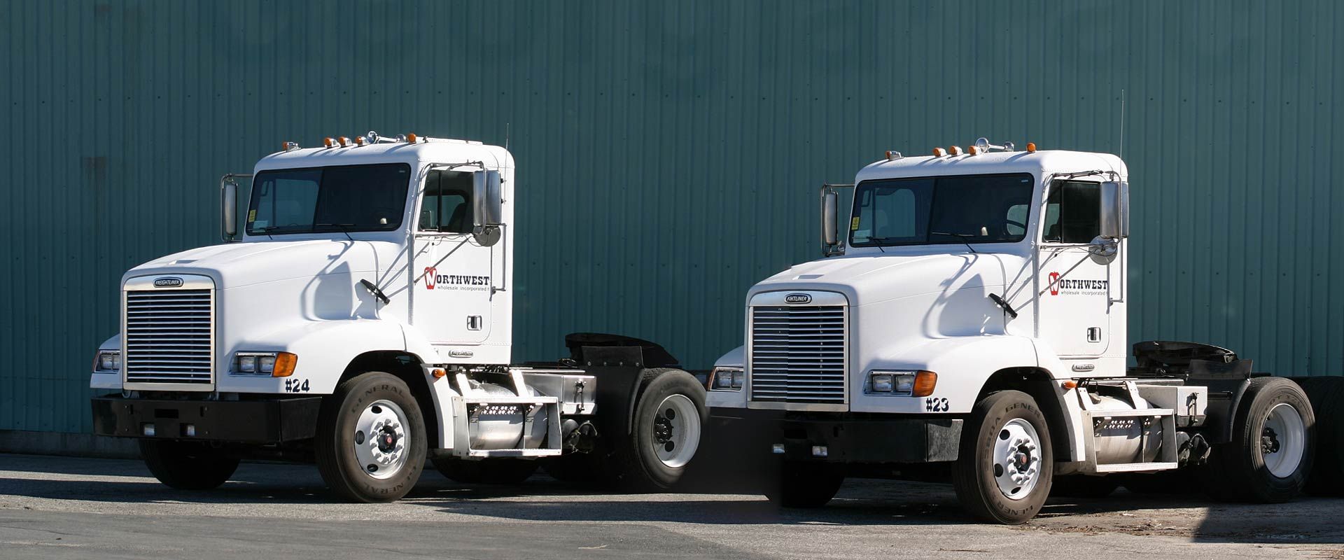 Two white semi trucks are parked next to each other