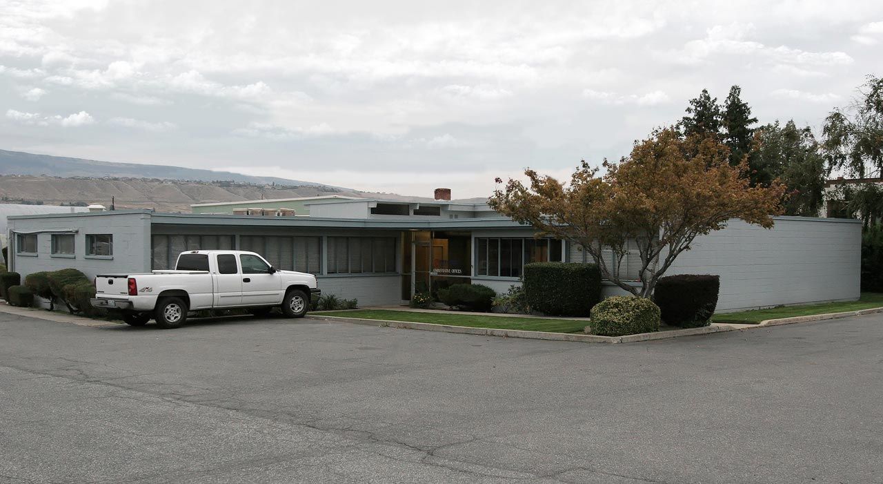 A white truck is parked in front of a house