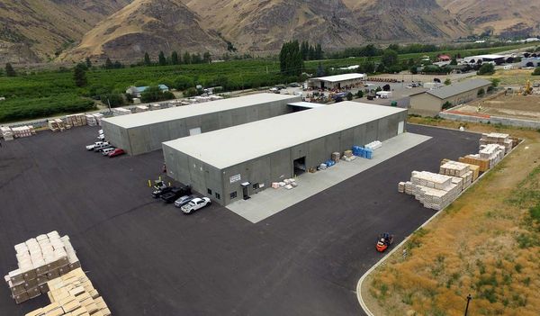 An aerial view of a warehouse with mountains in the background.