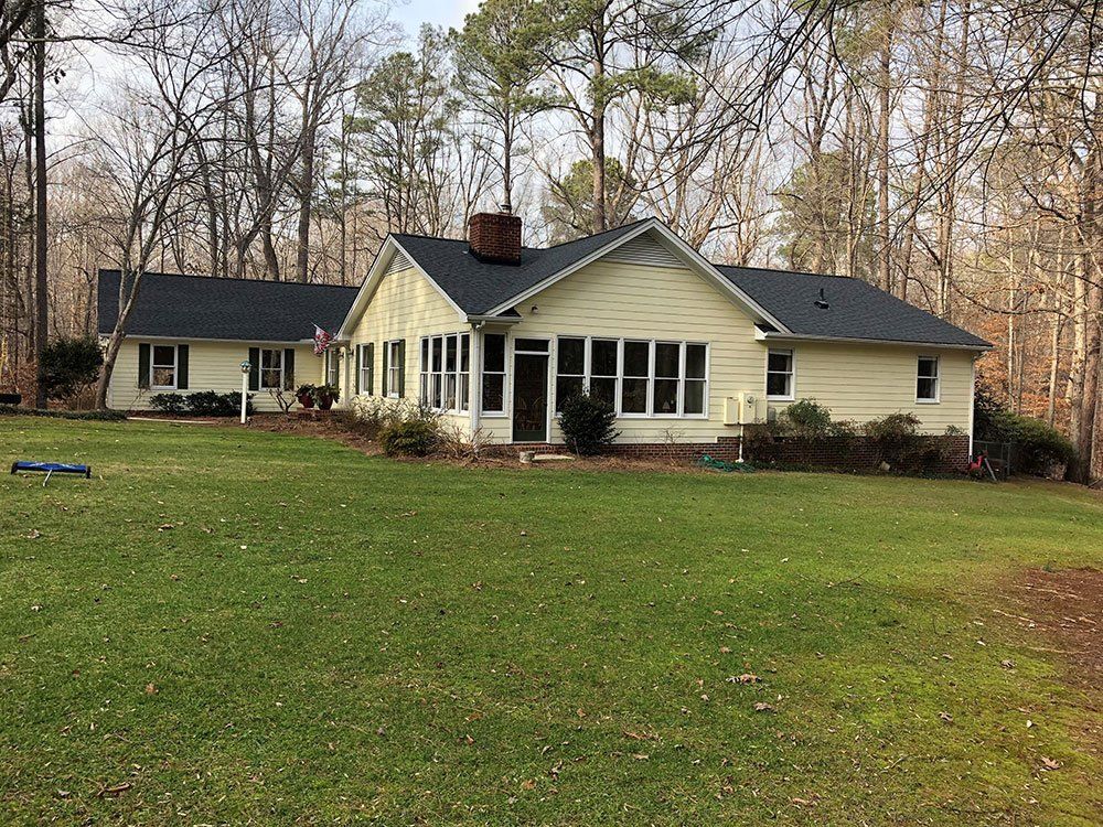 yellow house with new roof from Shield Roofing