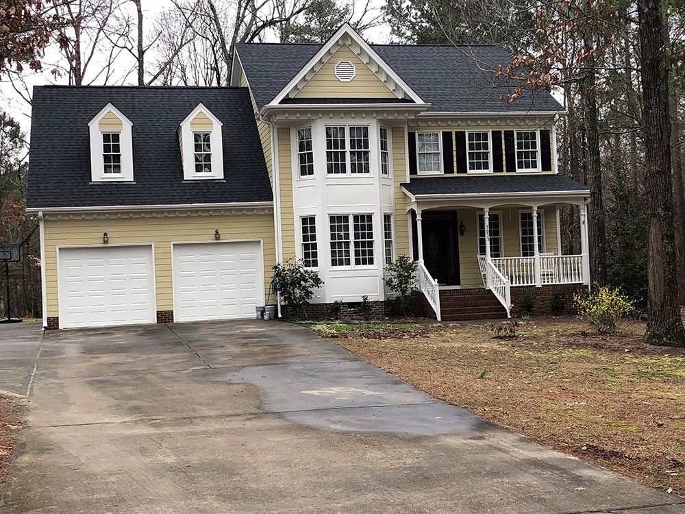 Yellow House with new roof from Shield Roofing