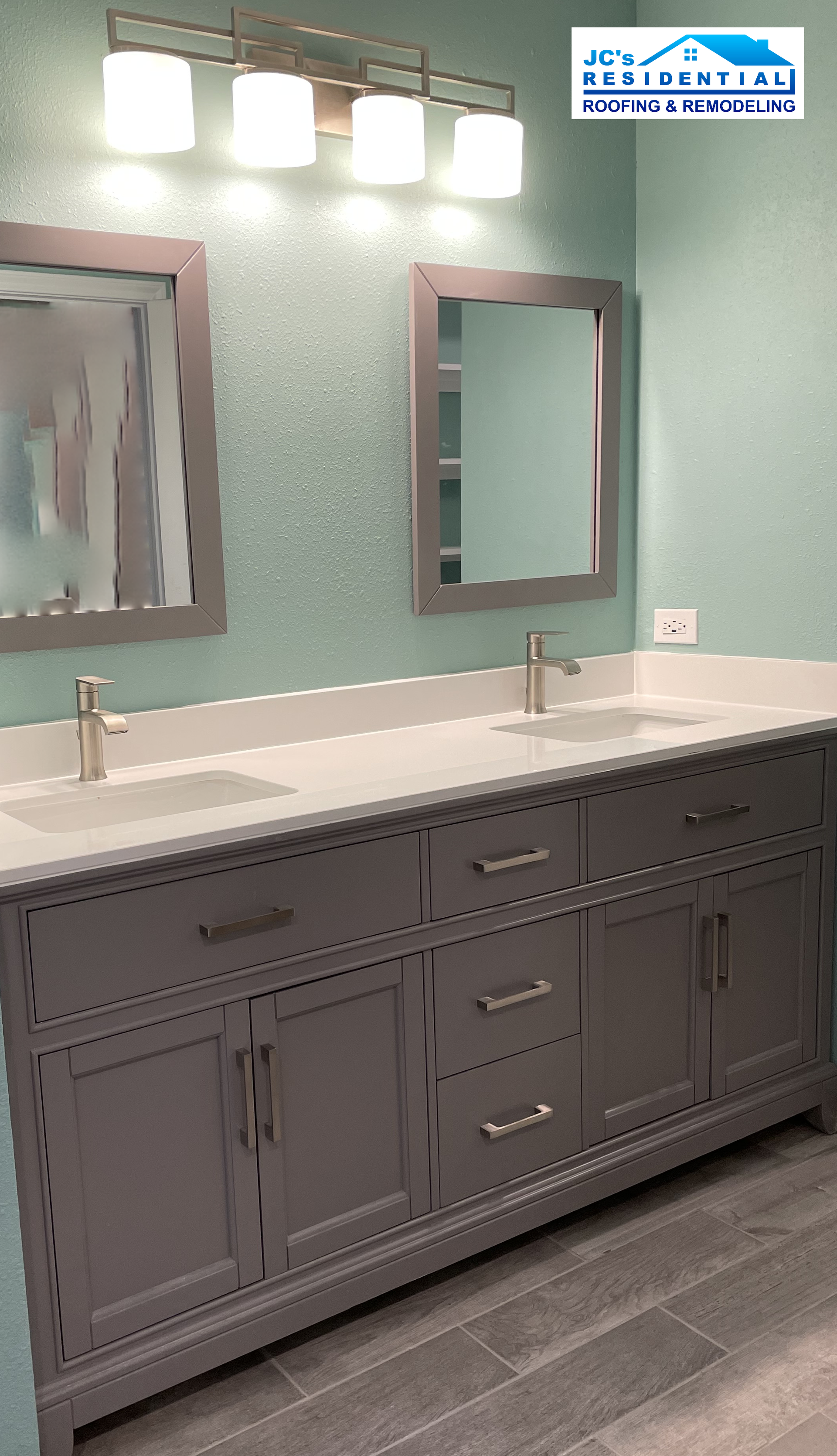 Gray double vanity with white countertop, mirrors, and brushed nickel faucets in a bathroom with aqua walls.