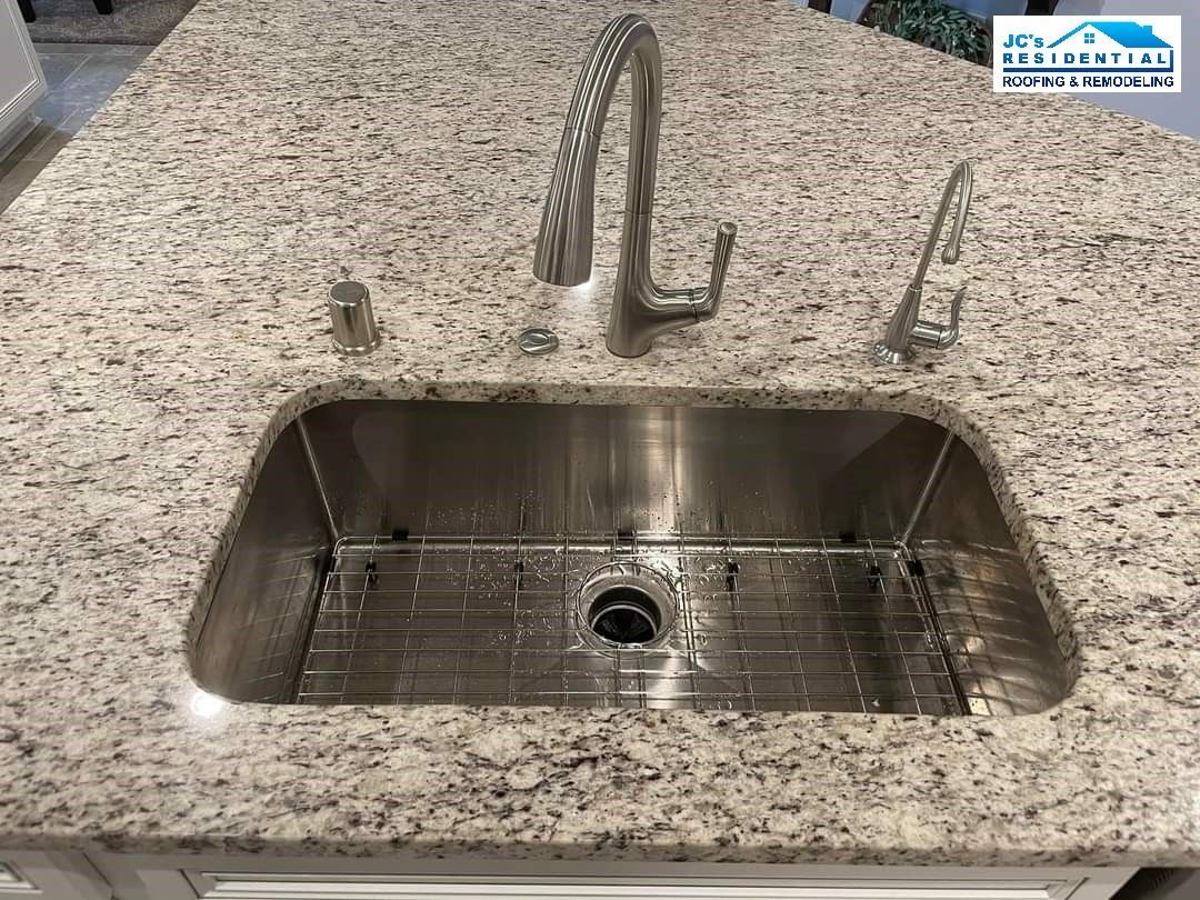 Stainless steel kitchen sink in granite countertop.