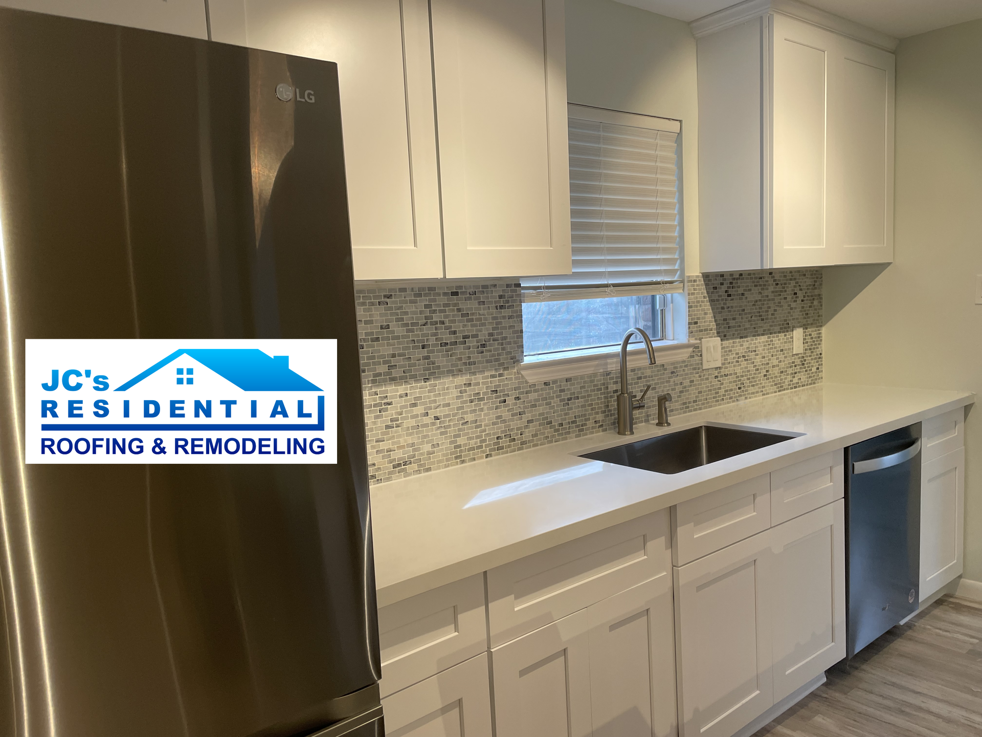 White kitchen cabinets and countertops with stainless steel appliances.