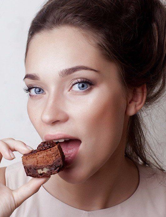 Woman eating brownie with perfect skin