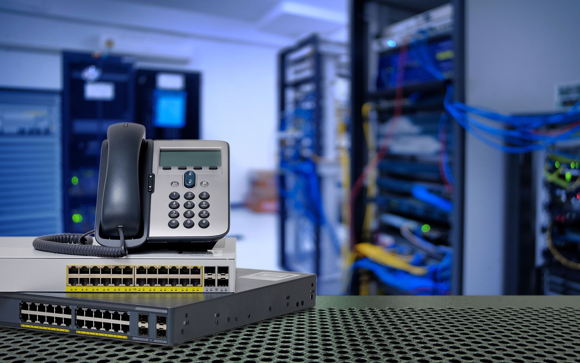 A telephone is sitting on top of a server in a server room.