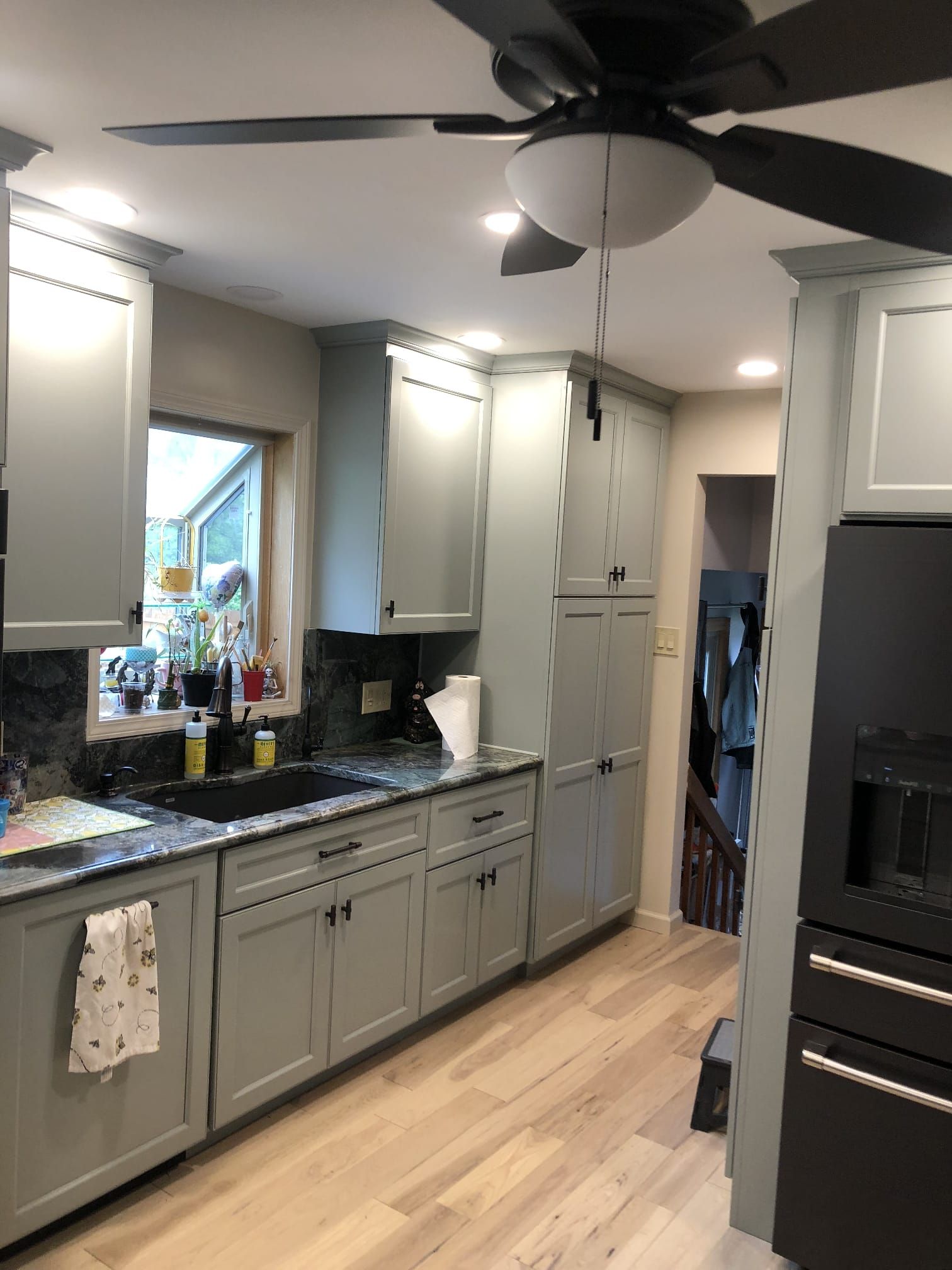 Partially renovated kitchen with cabinets, island, stove, window, and unfinished walls