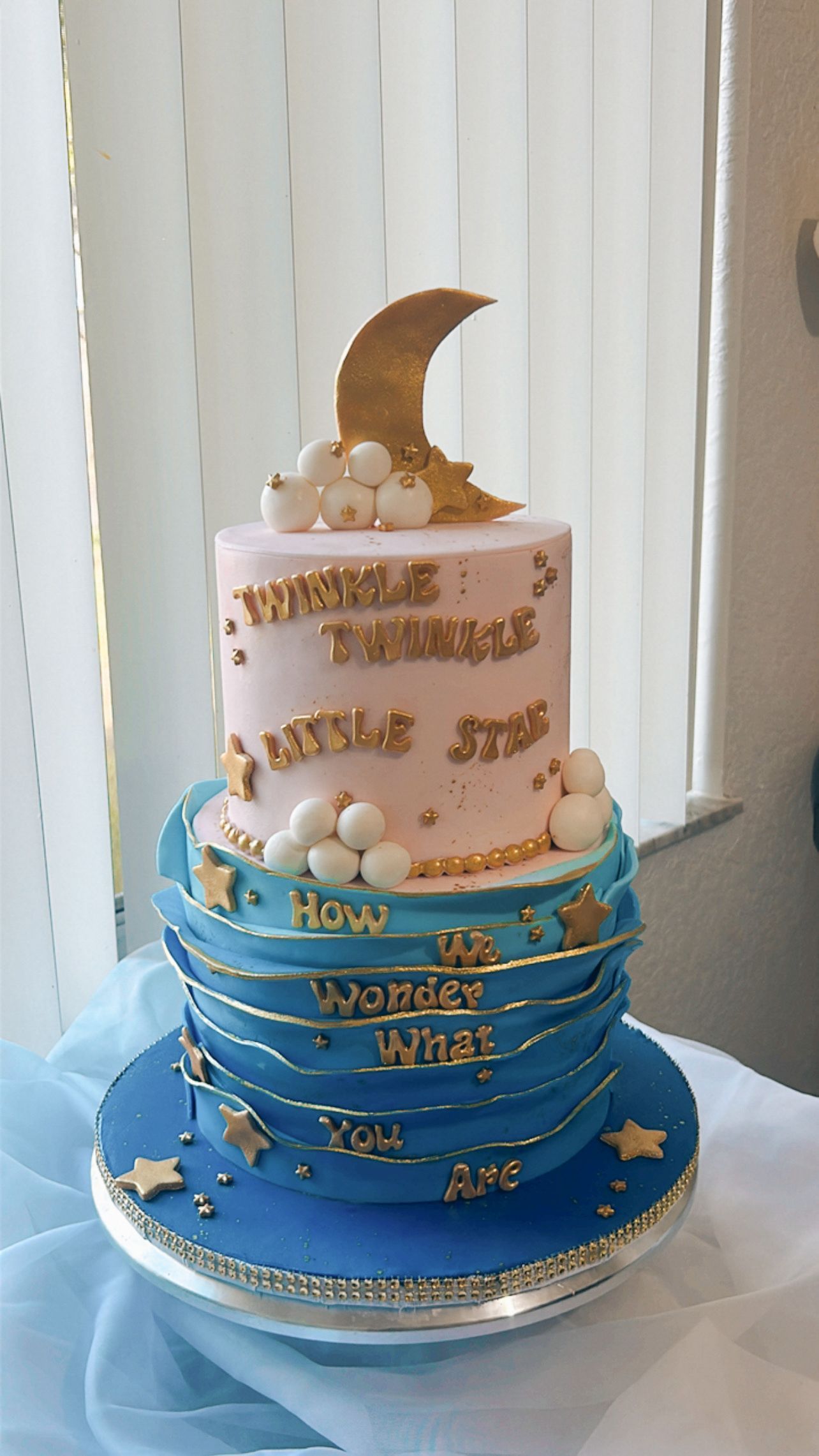A cake with a crescent moon on top of it is sitting on a table.