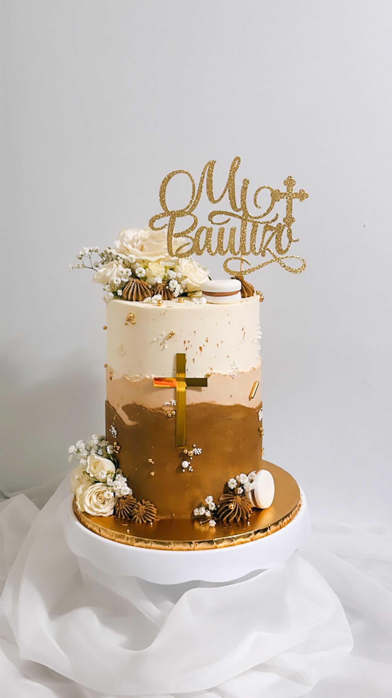 A cake with a gold cake topper is sitting on top of a white plate.