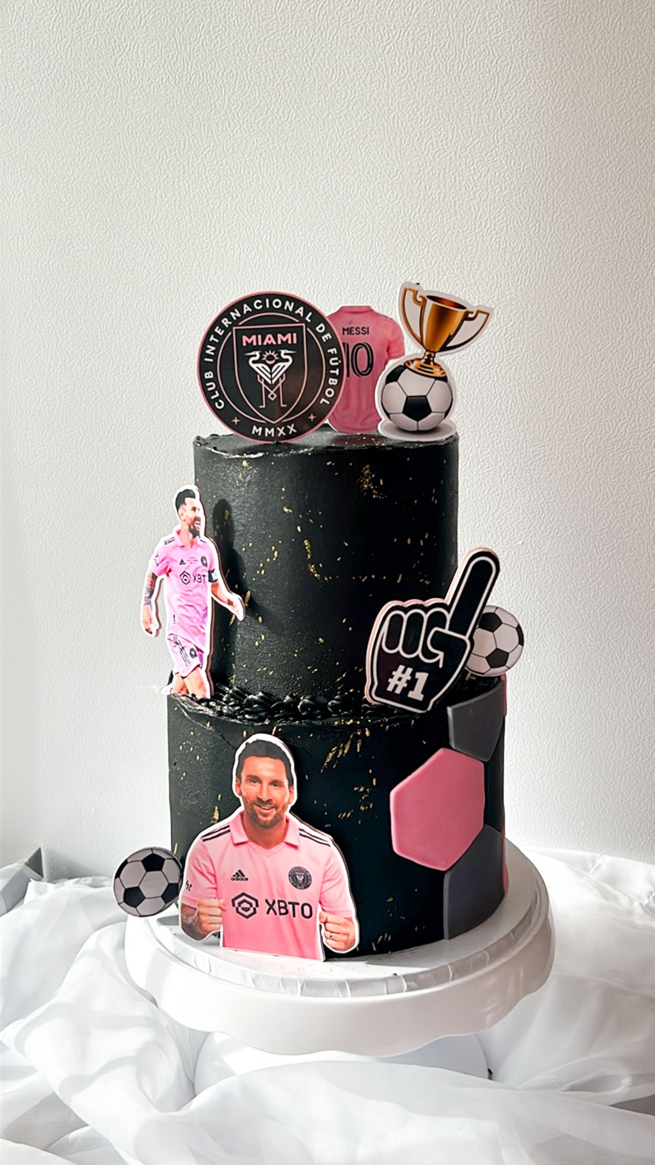 A black cake with a picture of a soccer player on top of it.