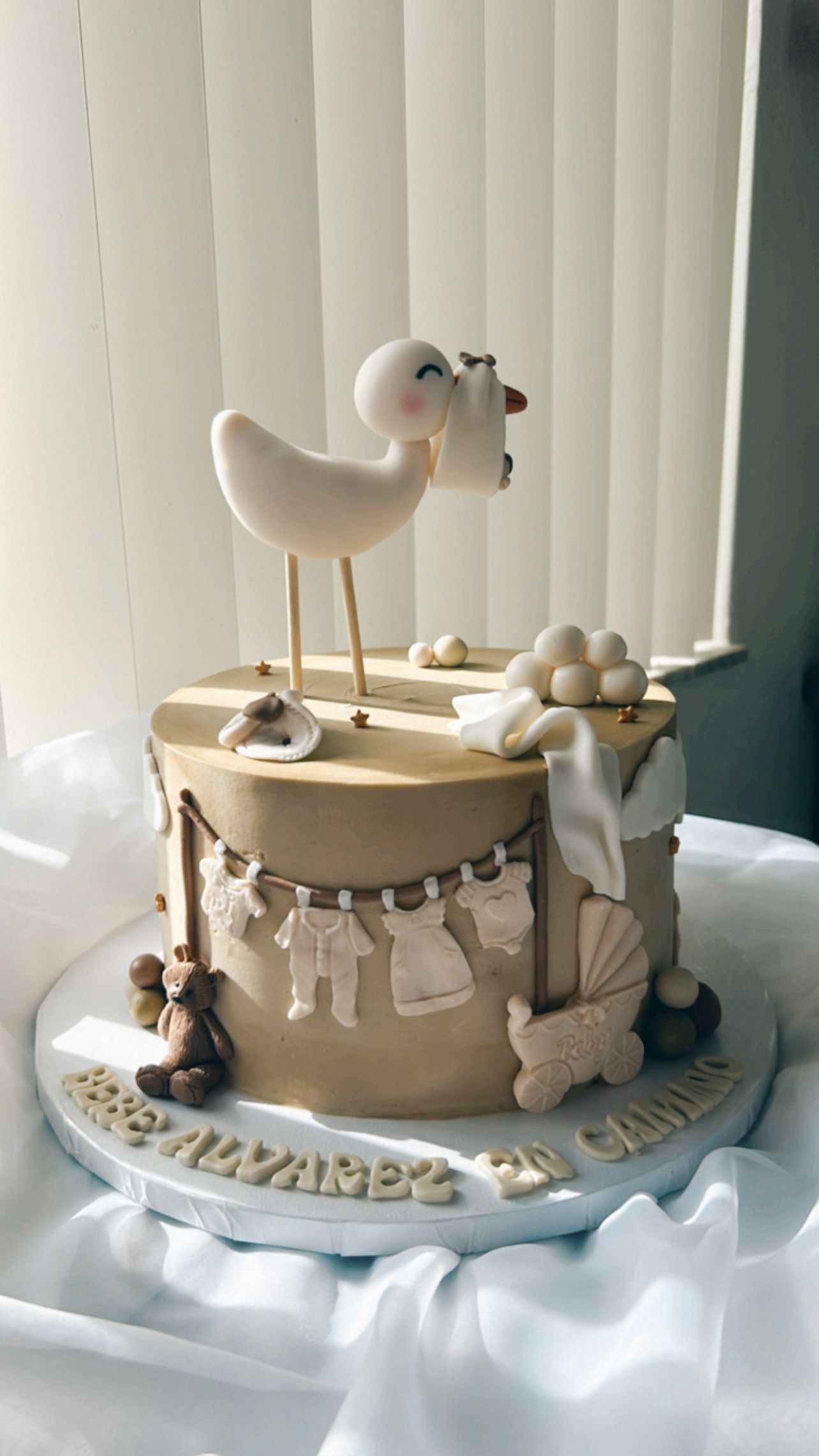 A baby shower cake with a stork on top of it