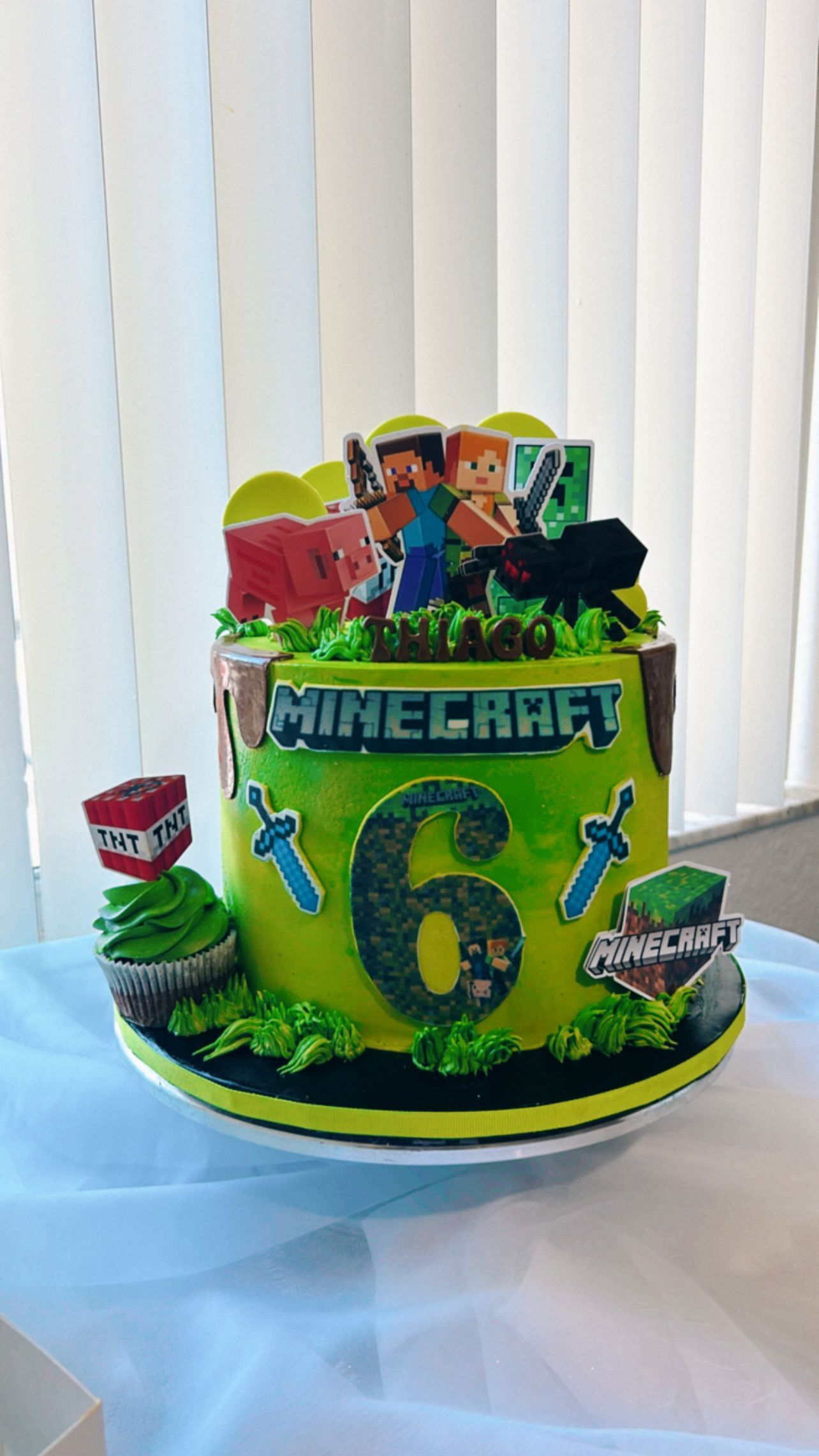 A minecraft cake is sitting on top of a white plate on a table.