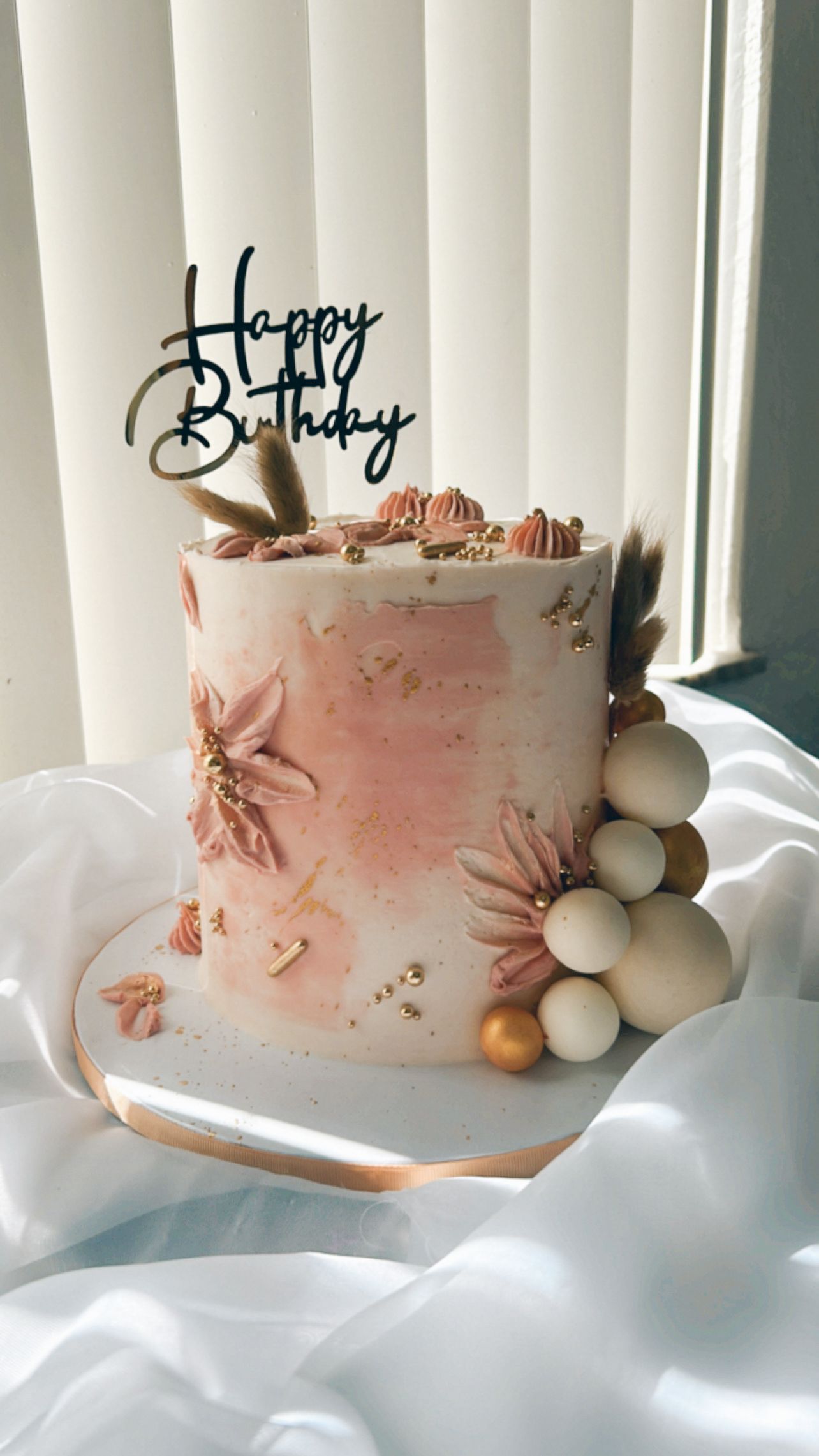 A birthday cake with a happy birthday topper is sitting on a table.