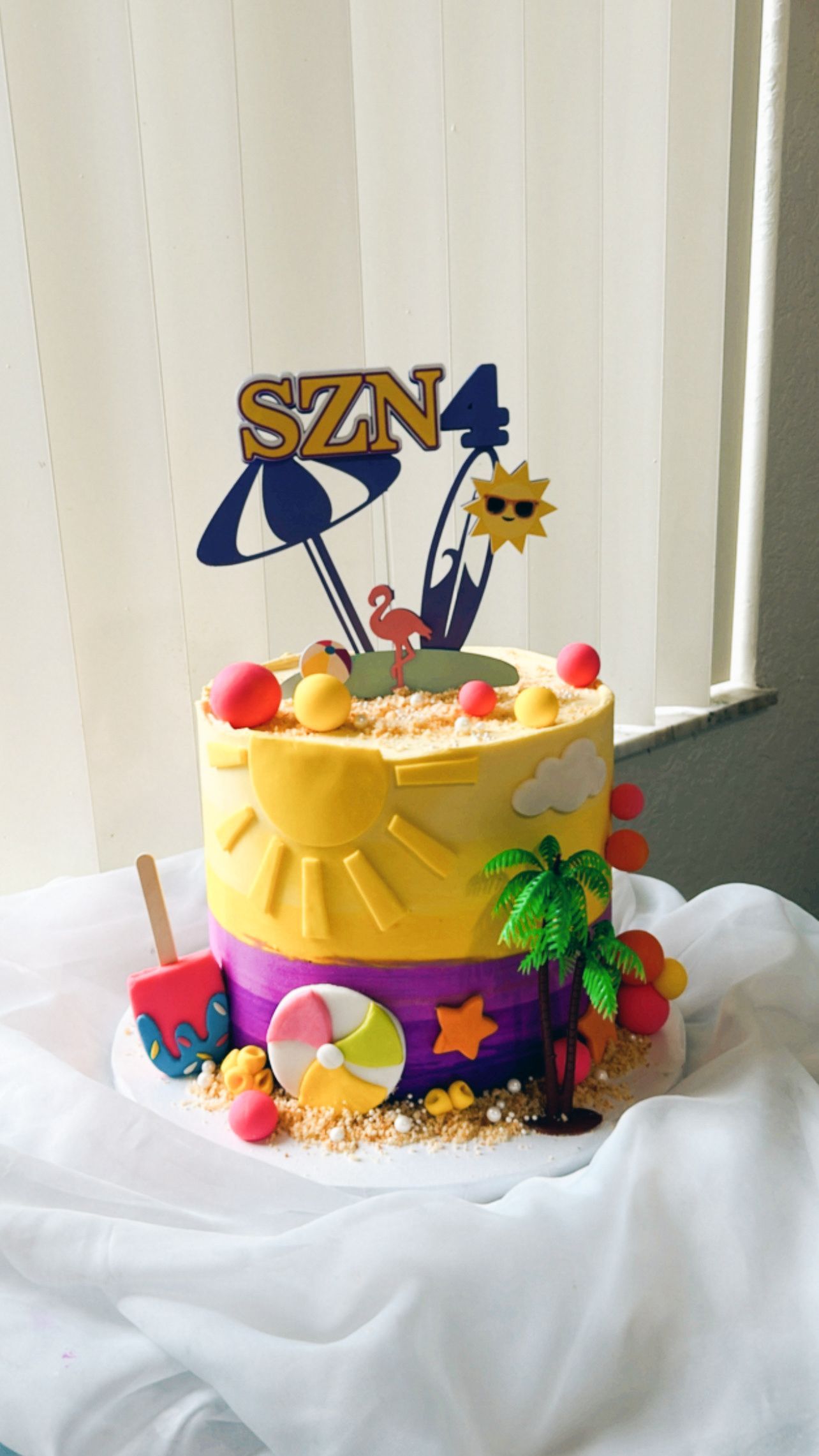 A yellow and purple cake with the name szn on top