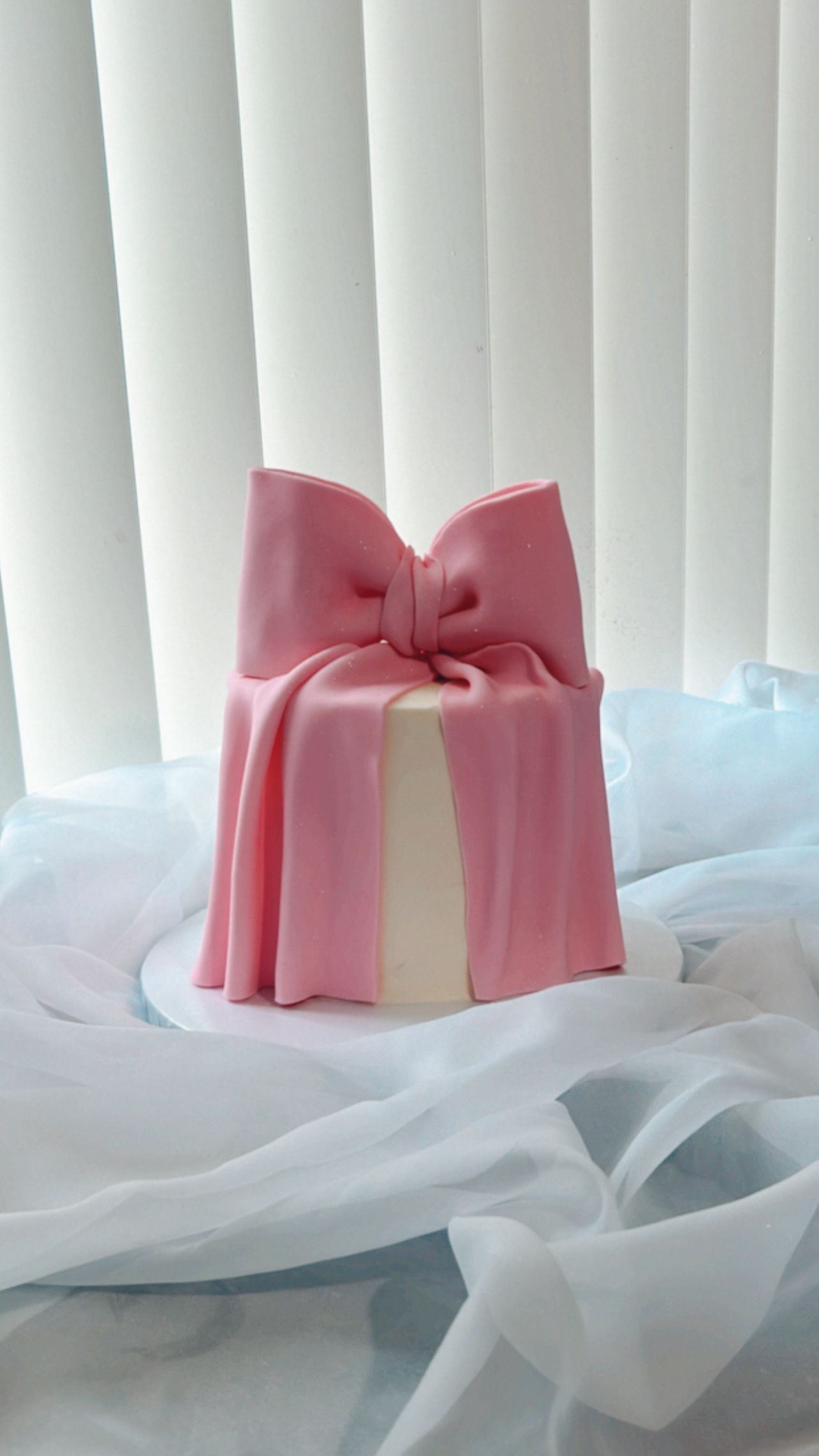 A cake with a pink bow on top of it