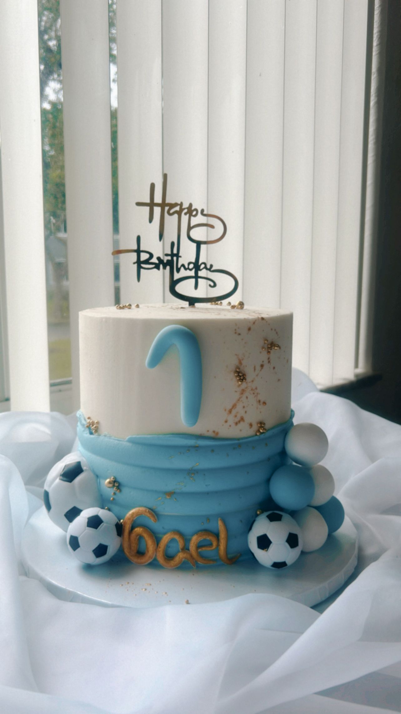 A birthday cake with soccer balls and the number 1 on it