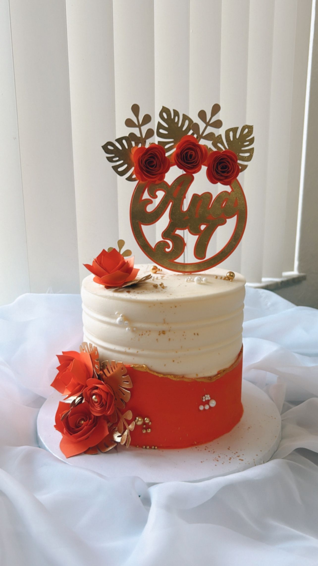 A cake with a topper on top of it is sitting on a table.