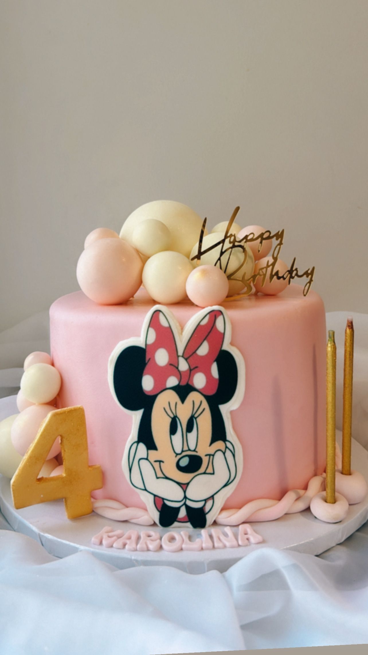 A pink cake with a picture of minnie mouse on it.
