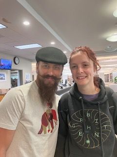 A man with a beard and mustache is posing for a picture with a woman.