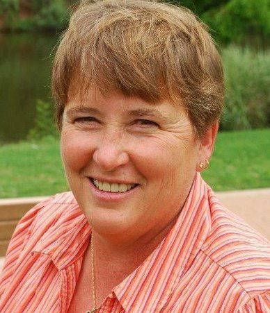 A woman in a striped shirt is smiling for the camera.