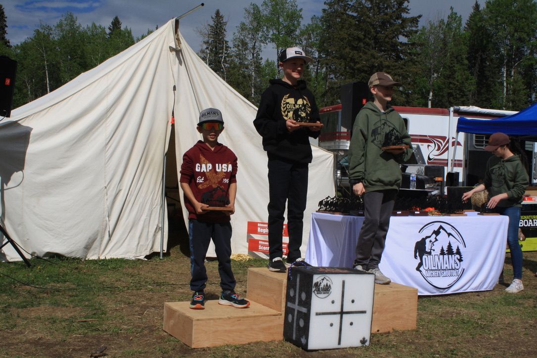 A group of people standing on a podium in front of a tent.