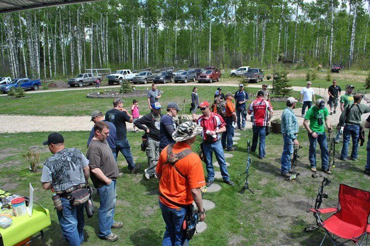 A group of people are standing in a grassy area.
