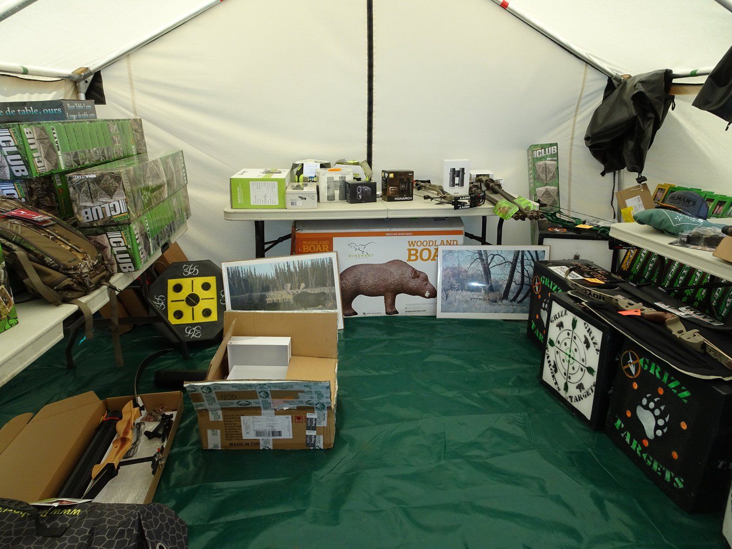 The inside of a tent filled with boxes and a bear painting
