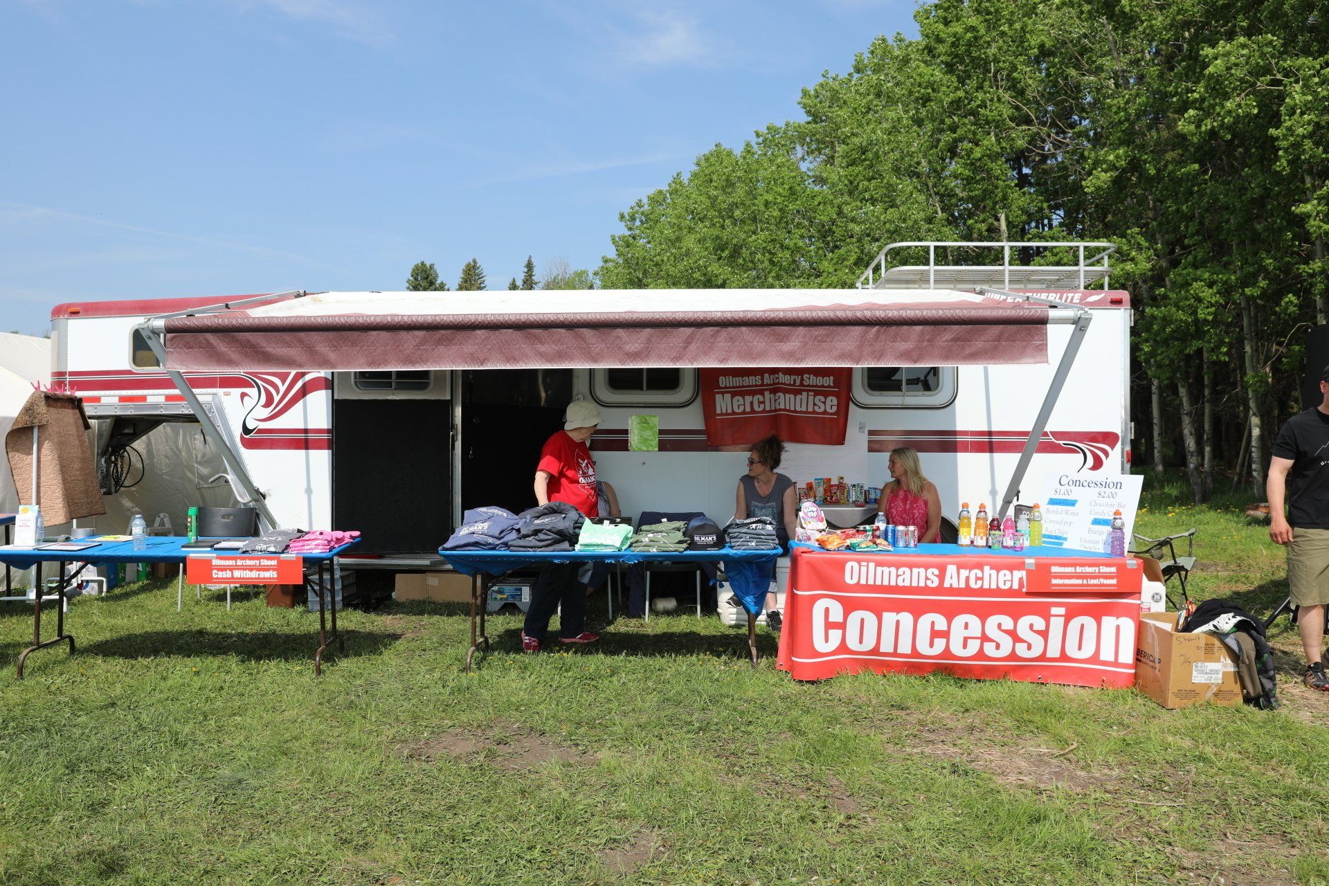 A concession stand in front of a trailer in a field