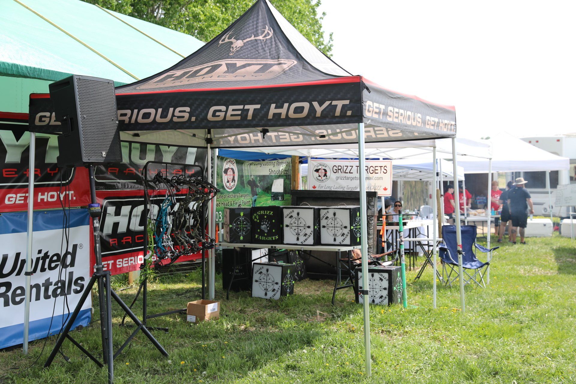 A group of tents in a field with one that says get hoyt