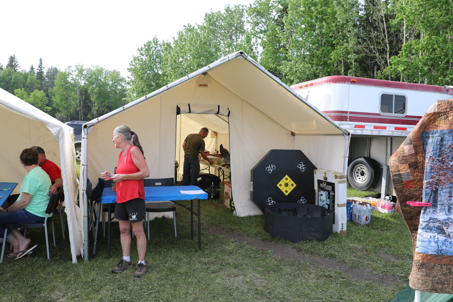 A group of people are standing outside of a tent